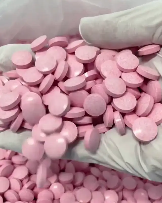 Pressed tablets in a gloved hand
